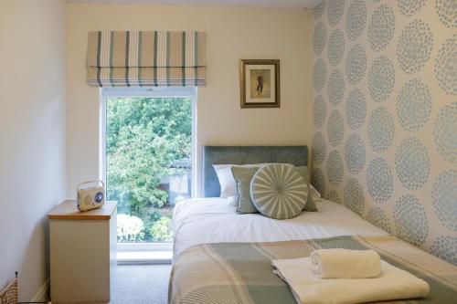 - une chambre avec un lit en face d'une fenêtre dans l'établissement Stylish family home in desirable Penylan + Parking, à Cardiff