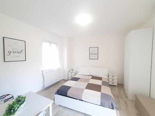 Dormitorio blanco con cama y mesa en Mini Suite Valentino, en Casale Monferrato