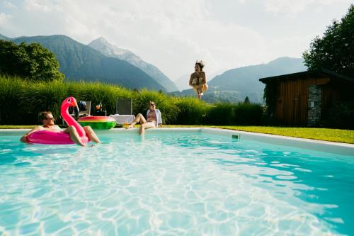 a group of people swimming in a swimming pool at Motorradhotel Gailtaler Hof in Kötschach