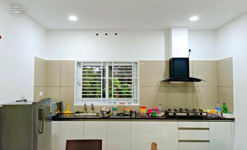 cocina con fregadero y ventana en Oryzaland Holiday Villa en Munnar