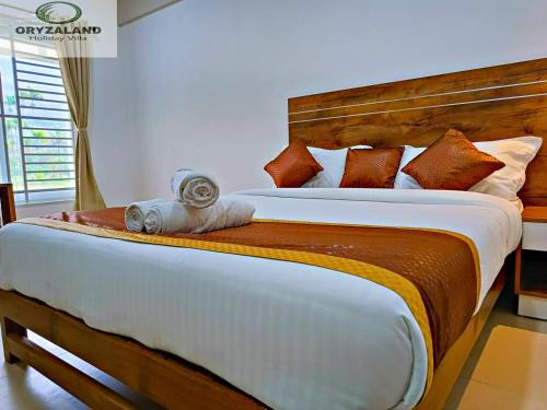 1 dormitorio con 1 cama grande y cabecero de madera en Oryzaland Holiday Villa en Munnar