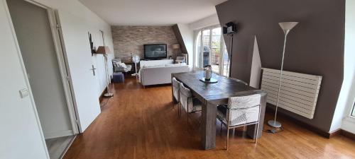 een woonkamer met een tafel en een woonkamer met een bank bij Midoon guest - The Balcony - Grand appartement Créteil proche Paris in Créteil