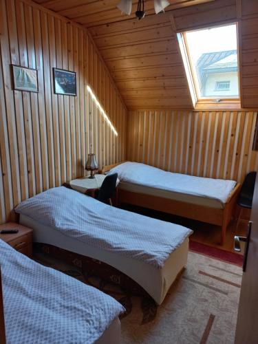 Maniowy的住宿－Noclegi u Zosi，客房设有两张床和窗户。