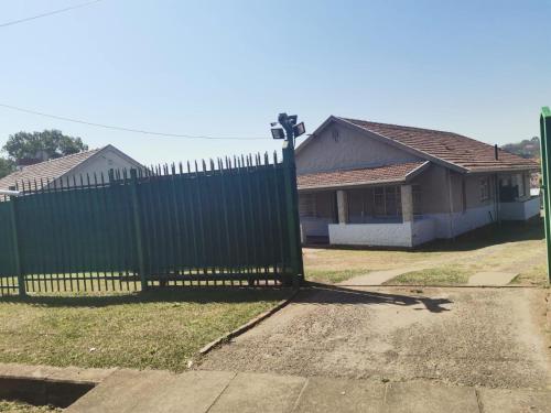 a green fence in front of a house at Daven Guest House in Pietermaritzburg