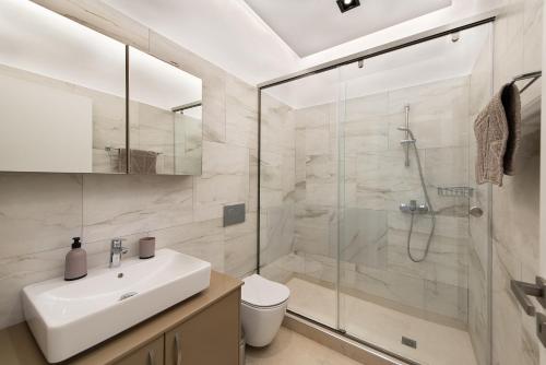 a bathroom with a shower and a sink and a toilet at Kimia Luxury Apartments in Kolimbia