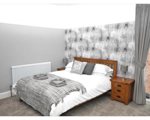 a bedroom with a bed with a black and white wallpaper at Victoria House in Southport