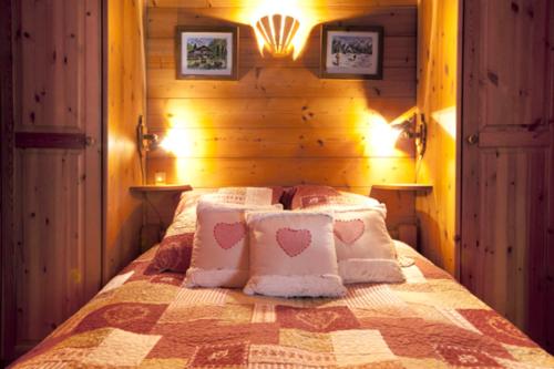 a bedroom with a bed with two pillows and two lights at Chalet Juliet 10 people in Montalbert