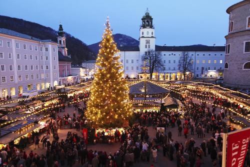 a christmas market in a city with a christmas tree at Hotel Vogelweiderhof in Salzburg