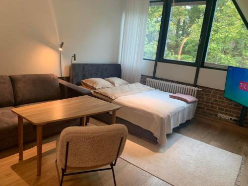 1 dormitorio con cama, mesa y sofá en Vallikraavi Studio Apartment en Tartu