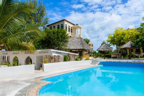 a villa with a swimming pool and a house at Geo Zanzibar Resort in Jambiani
