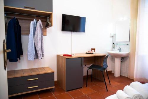 um quarto com uma secretária com um lavatório e uma televisão em Ballaro' Hotel - Budget Room em Palermo