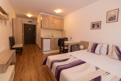 1 dormitorio con 1 cama grande y cocina en South Beach Apartment, en Nesebar
