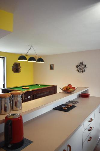 - une cuisine avec un comptoir et un billard dans l'établissement Le Noble Jardin, à Mohon