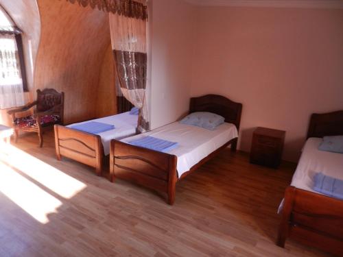 a bedroom with two beds in a room with wooden floors at Guest House Roman/Gonio in Gonio