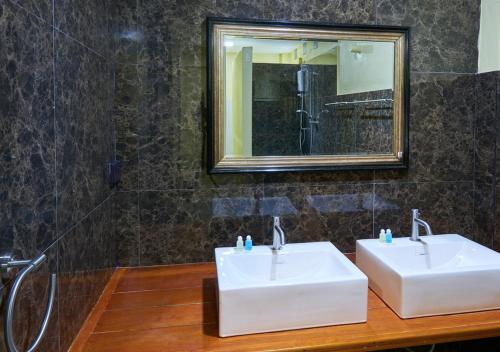 uma casa de banho com 2 lavatórios brancos e um espelho em Elephant Bay Resort em Ko Chang