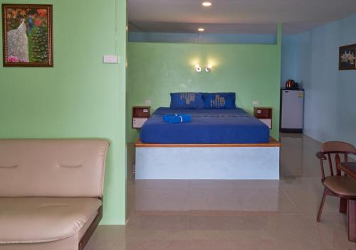 a bedroom with a blue bed and a couch at Elephant Bay Resort in Ko Chang