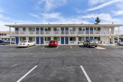a large building with cars parked in a parking lot at Super 8 by Wyndham Santa Clara in Santa Clara