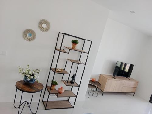 een kamer met een plank met een tafel en een tv bij Casa del Sol, la Paloma beach apartment with pool in Manilva