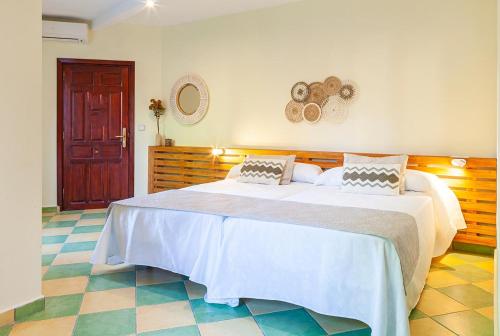 Hostal León Dormido في بولوب: غرفة نوم مع سرير أبيض كبير في غرفة