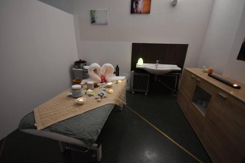 a room with a bed with a table with a sink at Hotel Il Cervo, SPA & Wellness, Bike Hotel in Tarvisio
