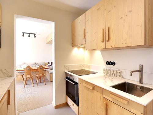 une cuisine avec un évier et une cuisinière four supérieur dans l'établissement Appartement Courchevel 3 Pièces, 6 Pers, Skis aux Pieds - FR-1-575-16, à Courchevel