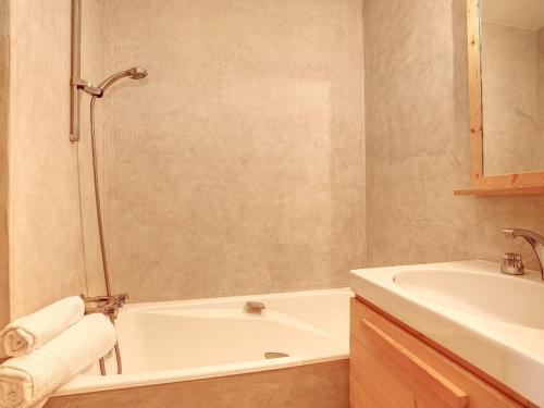 une salle de bain avec une baignoire et un lavabo et une baignoire dans l'établissement Appartement Courchevel 3 Pièces, 6 Pers, Skis aux Pieds - FR-1-575-16, à Courchevel