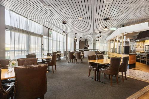a dining room with tables and chairs and windows at Best Western Eurostop Orebro in Örebro