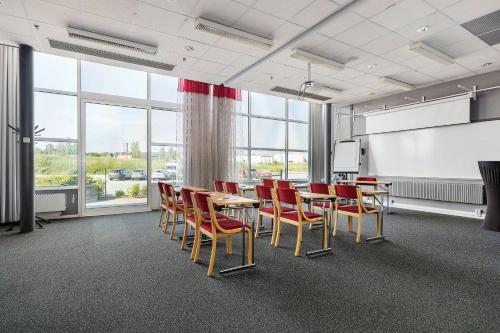a conference room with a table and chairs and a screen at Best Western Eurostop Orebro in Örebro
