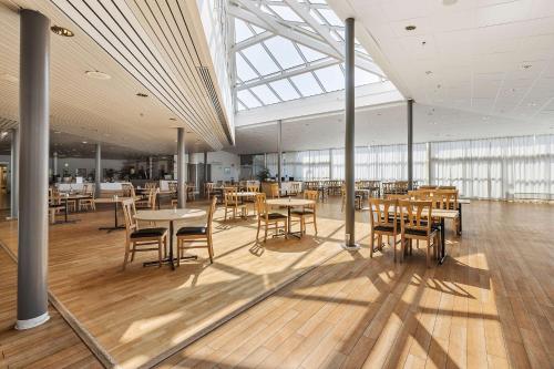 a dining room with tables and chairs in a building at Best Western Eurostop Orebro in Örebro
