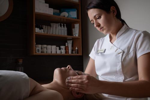 a woman getting a massage from a therapist at SPA VILNIUS Anykščiai in Anykščiai