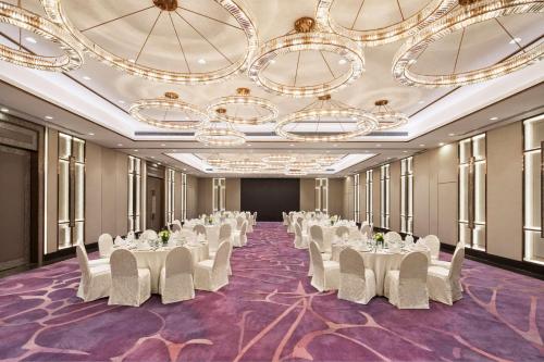a banquet hall with white tables and white chairs at Radisson Collection Hotel, Xing Guo Shanghai in Shanghai