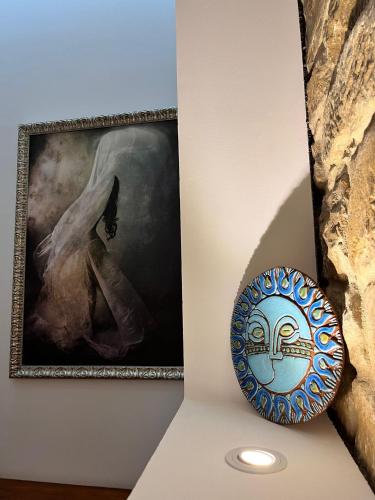 a painting on a wall next to a plate on a table at Hostal Casa de Luna y Sol in Úbeda