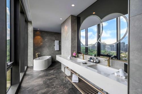 a bathroom with two sinks and a tub and windows at Radisson Collection Hotel, Vadistanbul in Istanbul