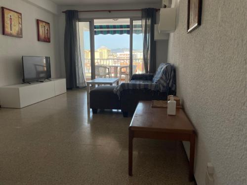 een woonkamer met een bank en een tv bij Apartamento Fuengirola beach in Fuengirola