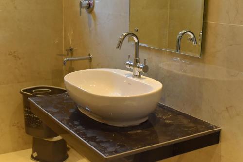 a white sink on a counter in a bathroom at The Divine Oak Golden Leaf in Katra