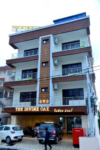 a building with cars parked in front of it at The Divine Oak Golden Leaf in Katra