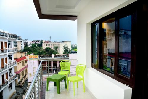 a balcony with two green chairs and a window at The Divine Oak Golden Leaf in Katra