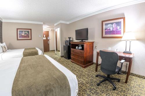 a hotel room with a bed and a desk with a computer at Salt Lake Plaza Hotel SureStay Collection by Best Western in Salt Lake City