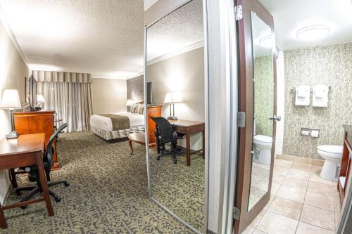 a hotel room with a bathroom with a bed and a desk at Salt Lake Plaza Hotel SureStay Collection by Best Western in Salt Lake City