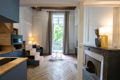 a room with a fireplace and a living room with a window at Le Chavannes -Ecrin élégant & Cosy - Pentes de la Croix Rousse in Lyon
