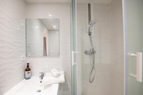 a white bathroom with a shower and a sink at Le Chavannes -Ecrin élégant & Cosy - Pentes de la Croix Rousse in Lyon
