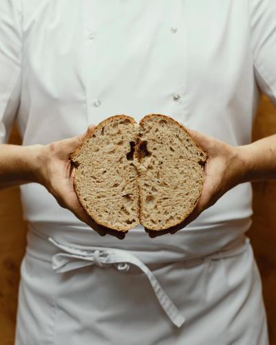 a woman holding a loaf of bread in her hands at Hotel Monopol in Katowice