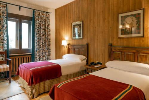 a hotel room with two beds and a window at Parador de Bielsa in Espierba