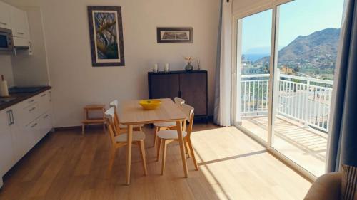 cocina con mesa y sillas y balcón en Casa Efraim en Hermigua