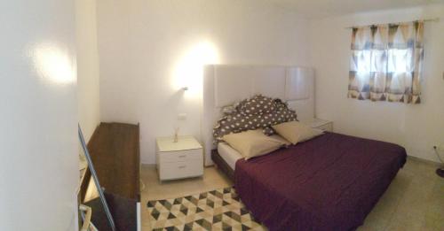a small bedroom with a bed and a night stand at Emplacement idéal pour cette Maisonnette avec jardin et cuisine d'été in Roquebrune-Cap-Martin