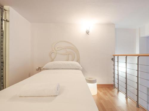 uma cama branca num quarto branco com uma parede branca em La muralla de Sevilla em Sevilha