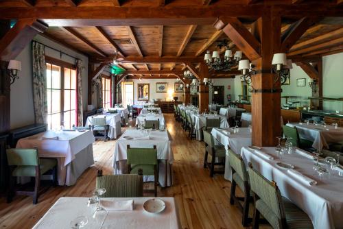 a dining room with white tables and chairs at Parador de Bielsa in Espierba