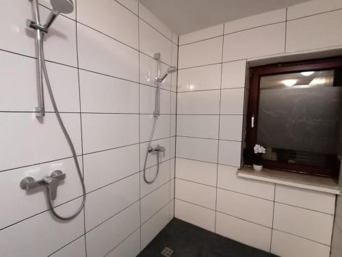 baño con ducha, ventana y TV en MK Hostel Bremen, en Bremen