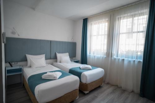 a hotel room with two beds and a window at Hotel Civitas in Sopron
