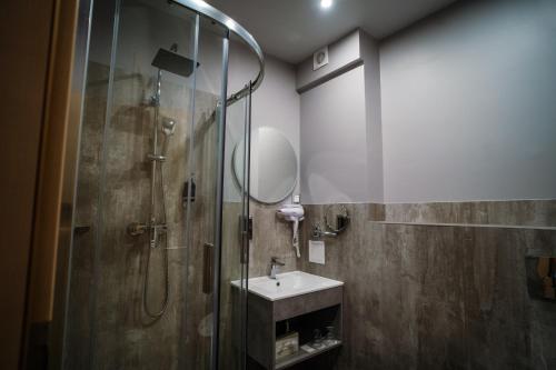 a bathroom with a shower and a sink and a mirror at Hotel Civitas in Sopron